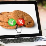 Macbook with cookies and tick and cross options on screen.